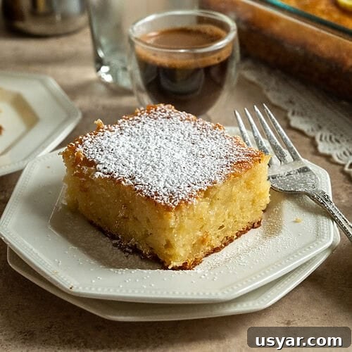 Lemonopita: Greek Lemon Cake with Phyllo 17 A piece of lemonopita cake on a white plate, and topped with a sprinkle of icing sugar, with a Greek coffee next to it.