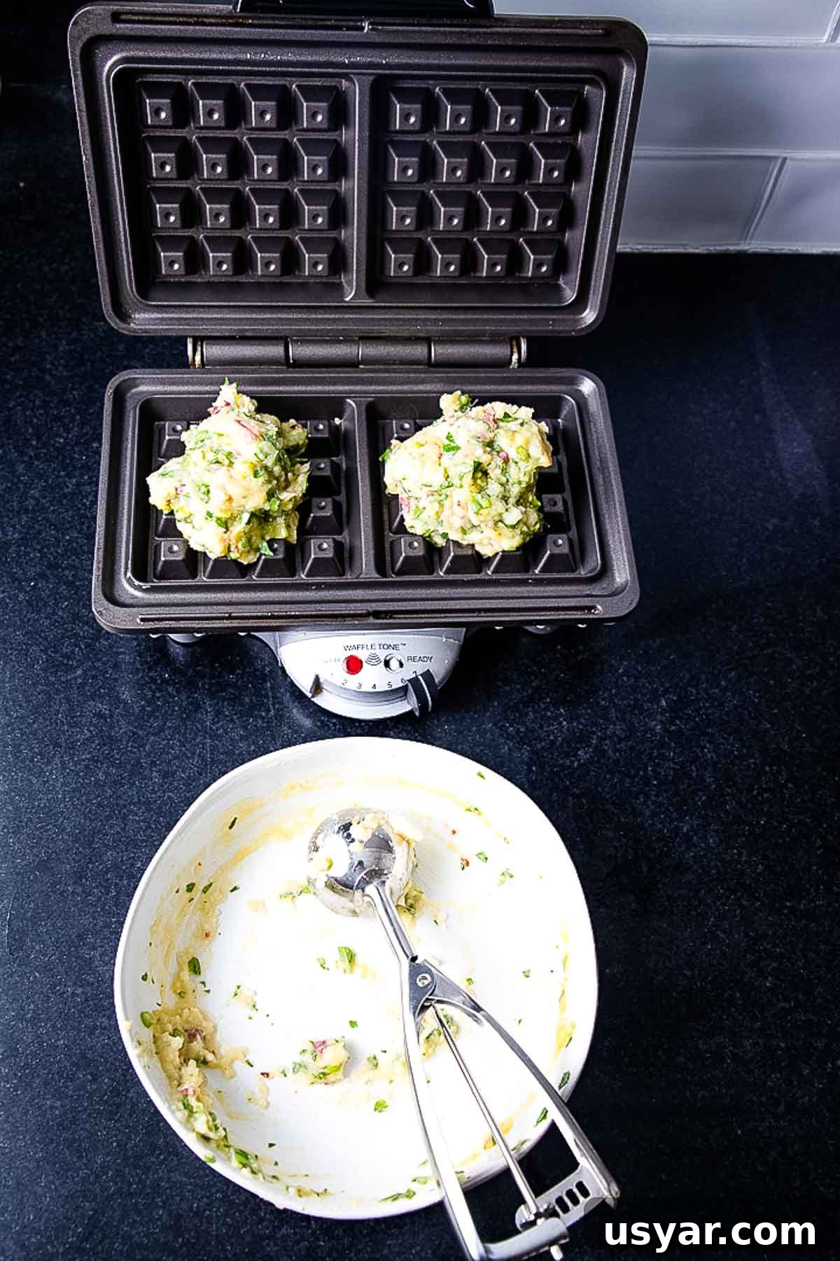 Crispy Leftover Mashed Potato Waffles 7 Waffle maker with large portions of potato waffle batter. Empty bowl with cookie scoop.