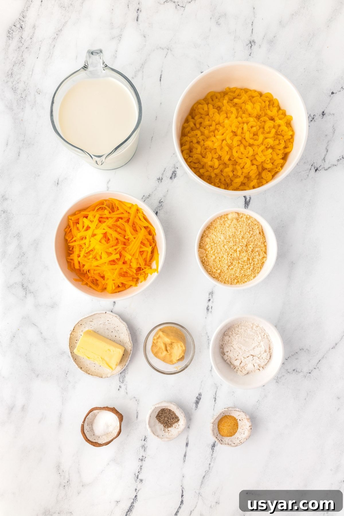 Creamy Stovetop Macaroni and Cheese 4 Creamy milk and shredded cheese in bowls, with pasta, butter, mustard, and seasonings ready for a cheese sauce.