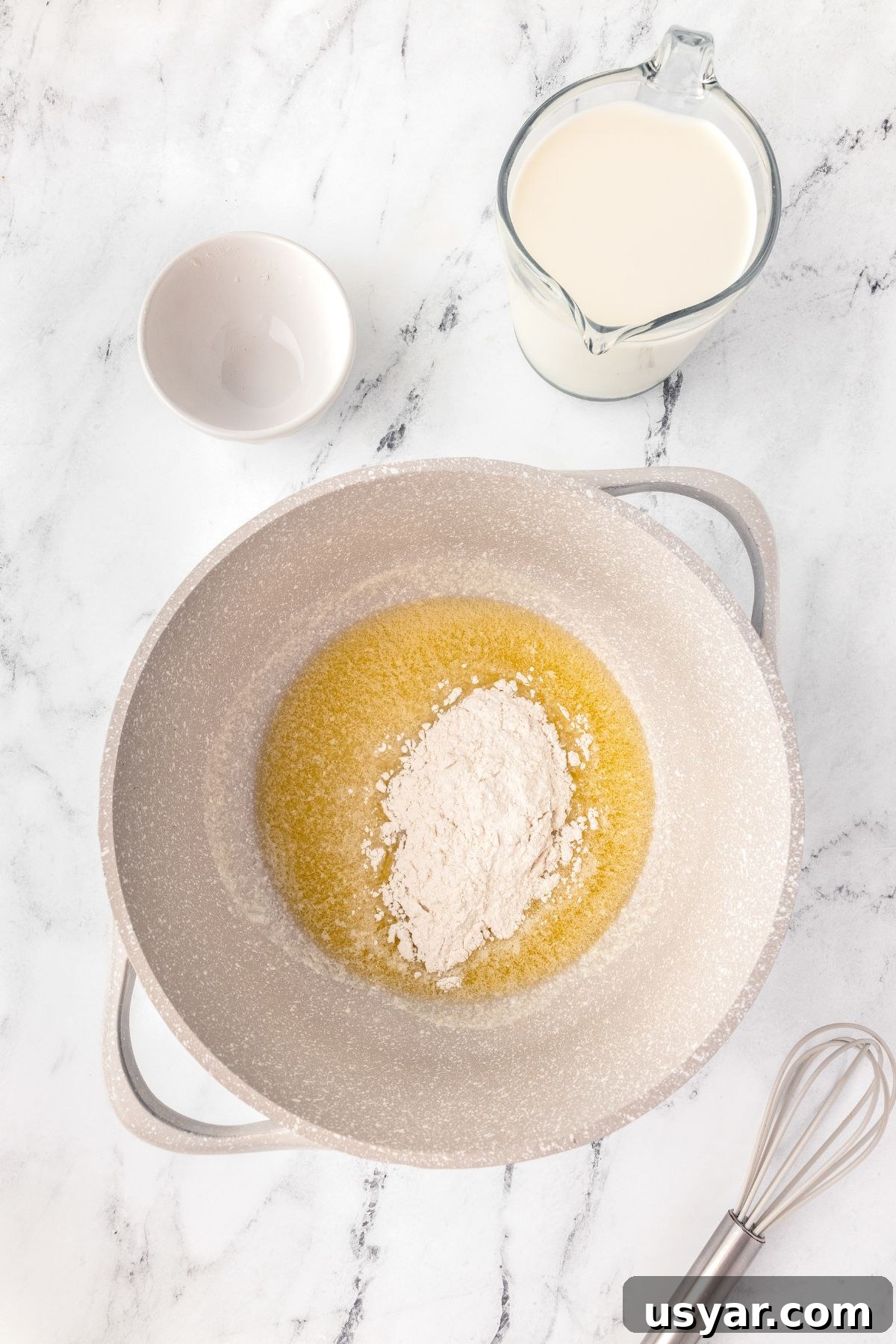 Creamy Stovetop Macaroni and Cheese 6 Flour and butter in a mixing bowl with milk and a whisk.